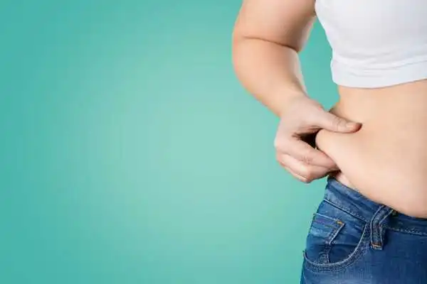 Image of woman pinching her love handles to show weight gain Coombe